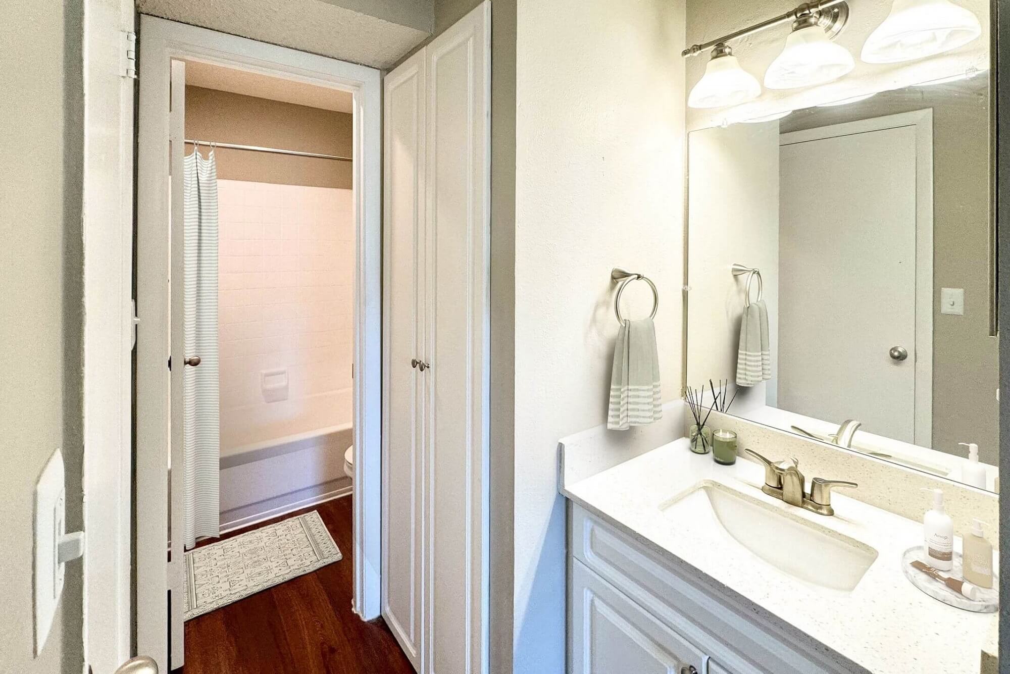 bathroom with wood-style flooring, single sink, mirror, and a shower/bath combo.