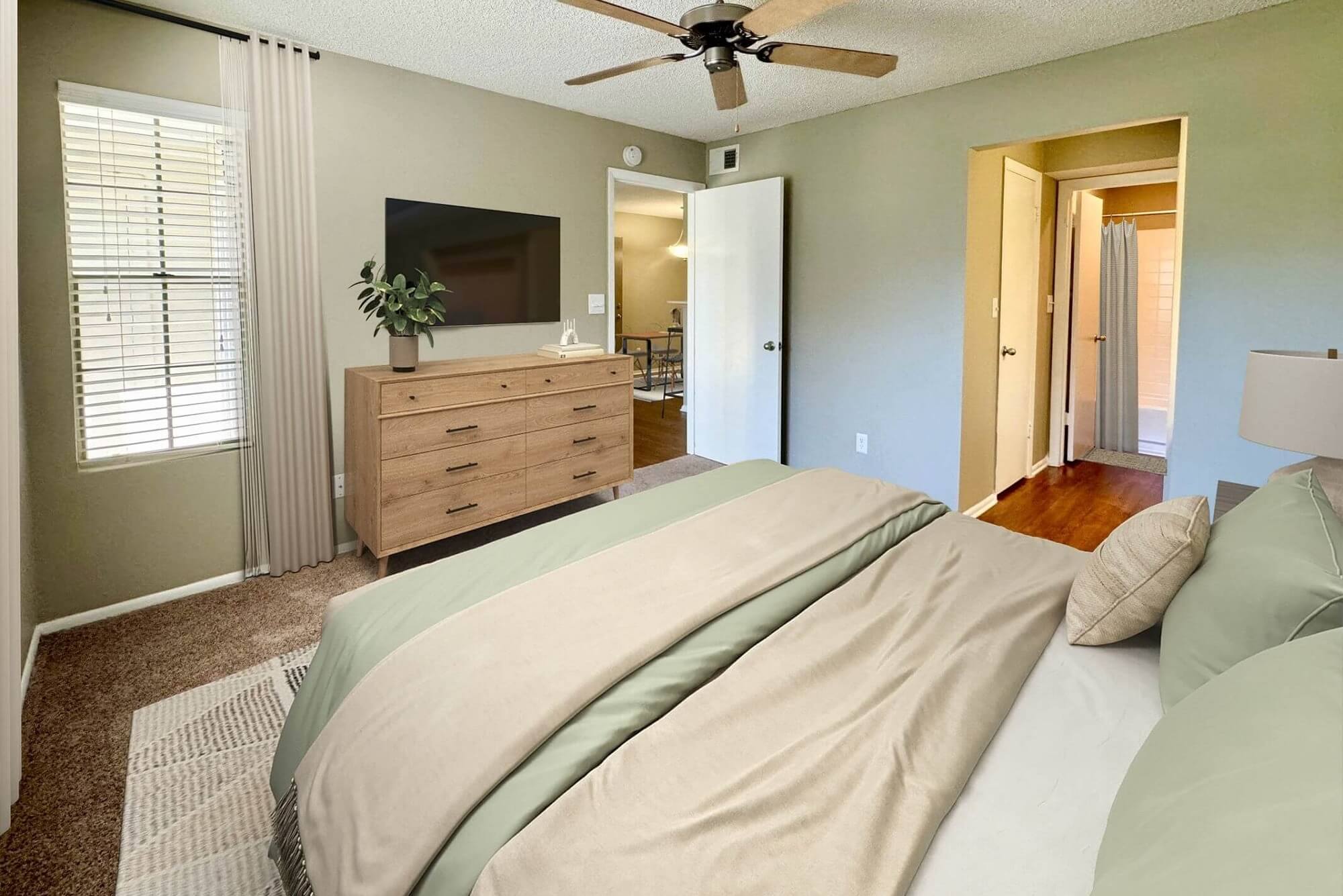 bedroom with carpet flooring, windows, and mounted television.
