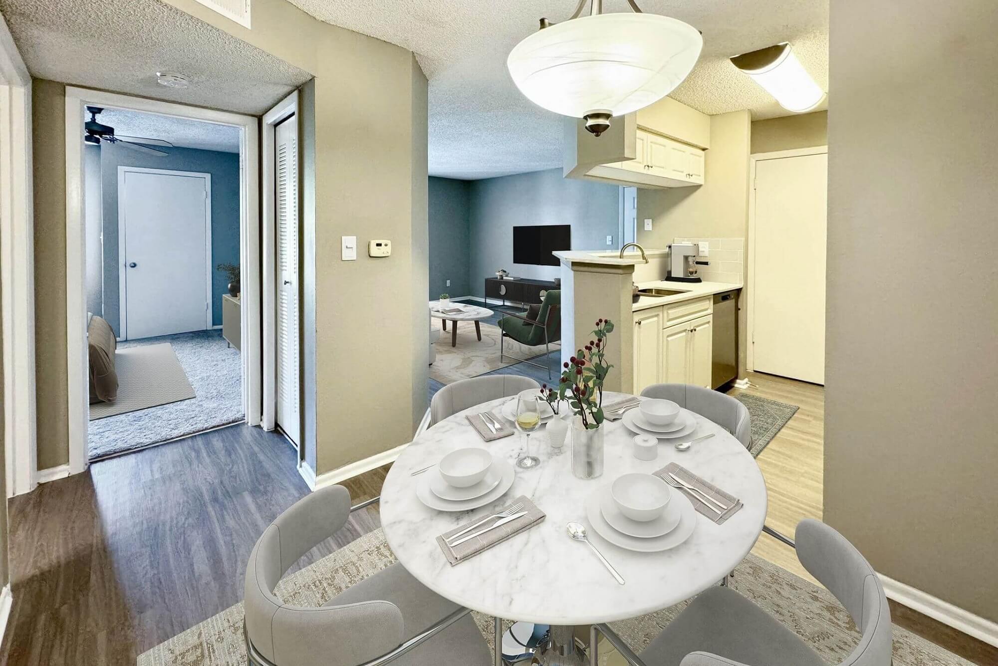 dining room with wood-style flooring, designer lighting, dining table with silverware, and open access to kitchen, living room and bedroom.