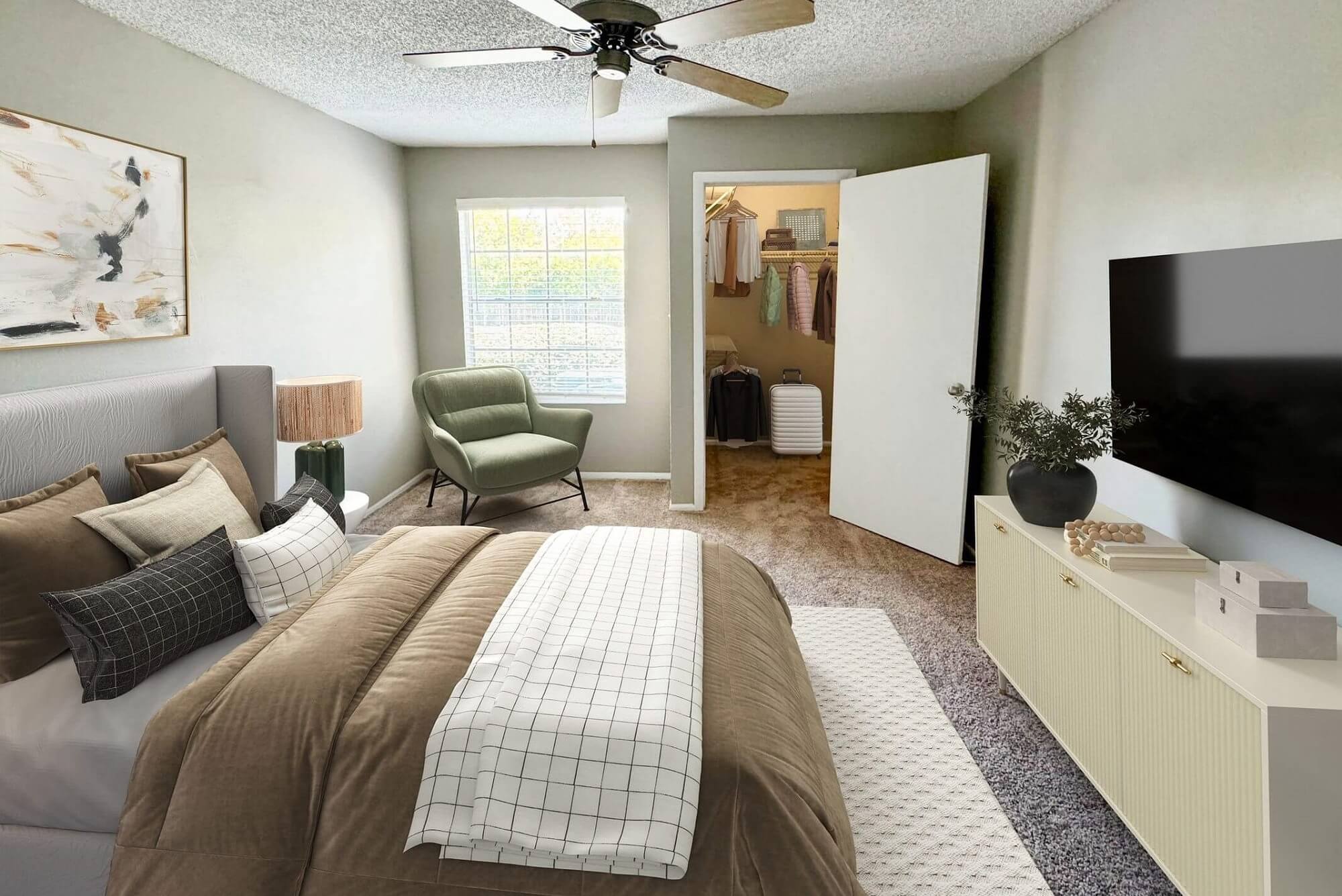 bedroom with carpet flooring, mounted television, window, and spacious closet.