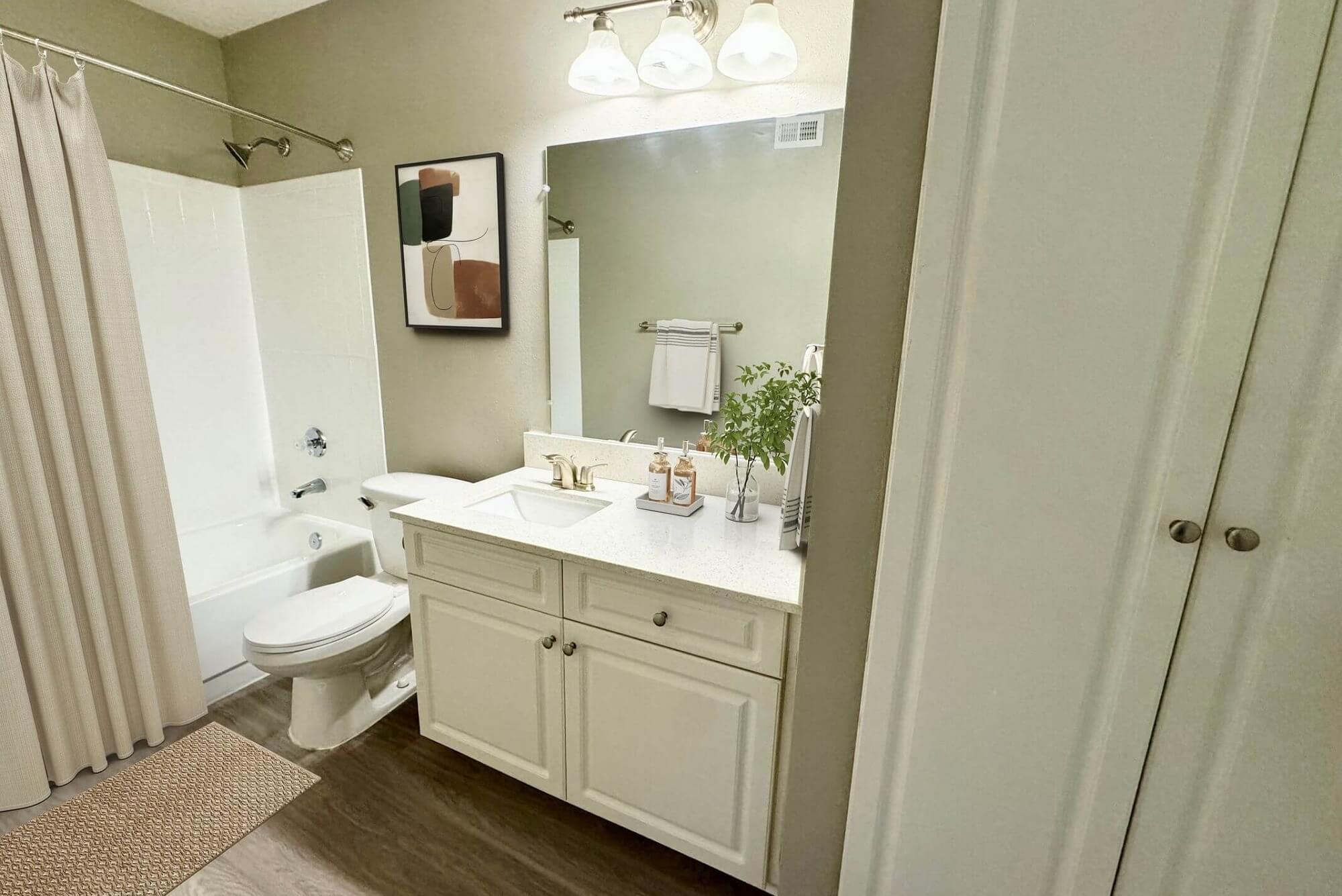 bathroom with wood-style flooring, mirror, single sink, and shower/bath combo.