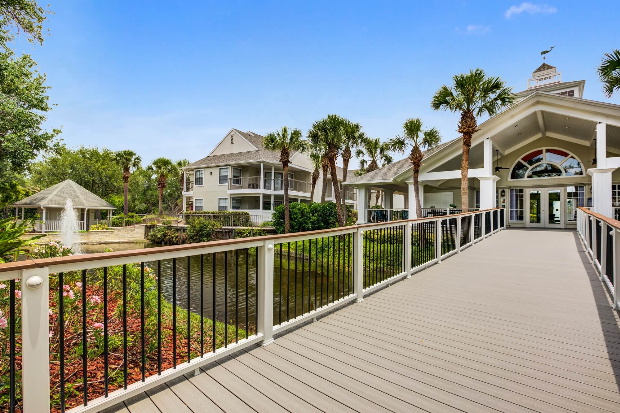 long wooden walkway to clubhouse with view of the fountain.