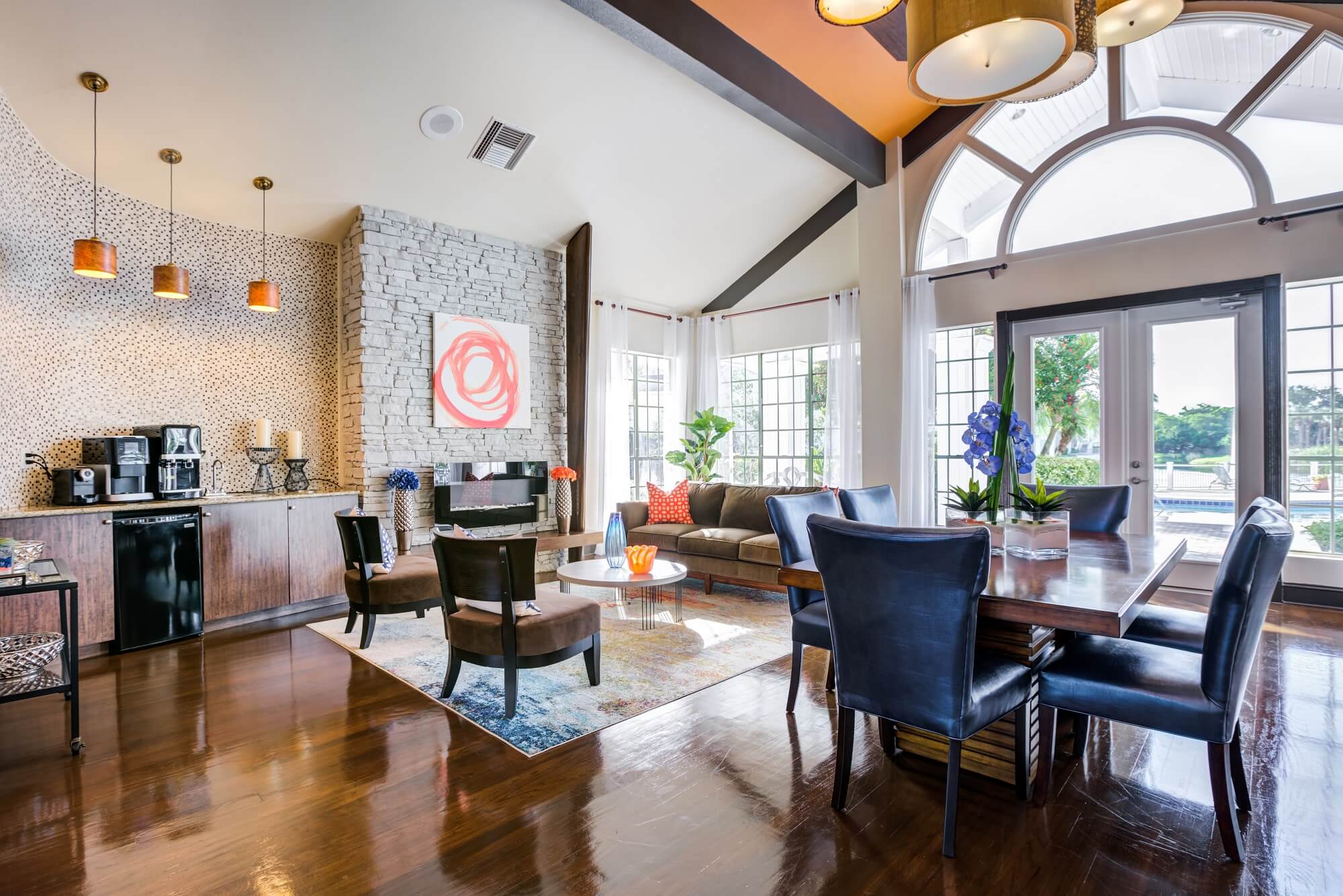 clubhouse interior with couches, chairs, coffee bar, fireplace, and tables.