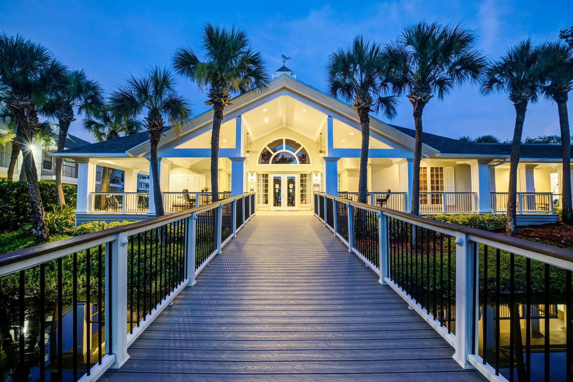 night time view of long wooden walkway to clubhouse.