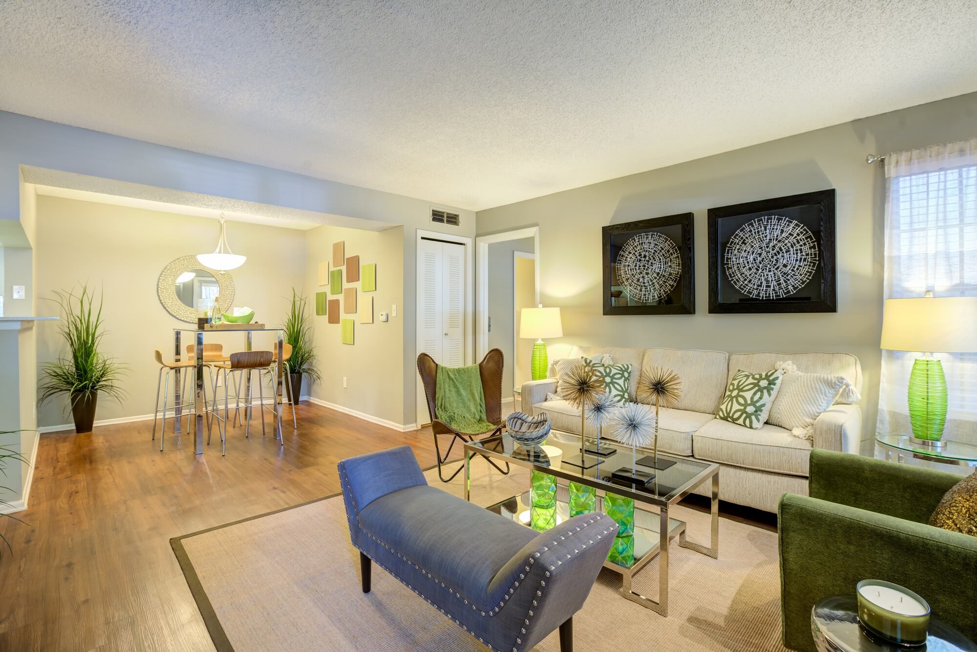 living and dining area with decor, overhead lighting, and wood floors.