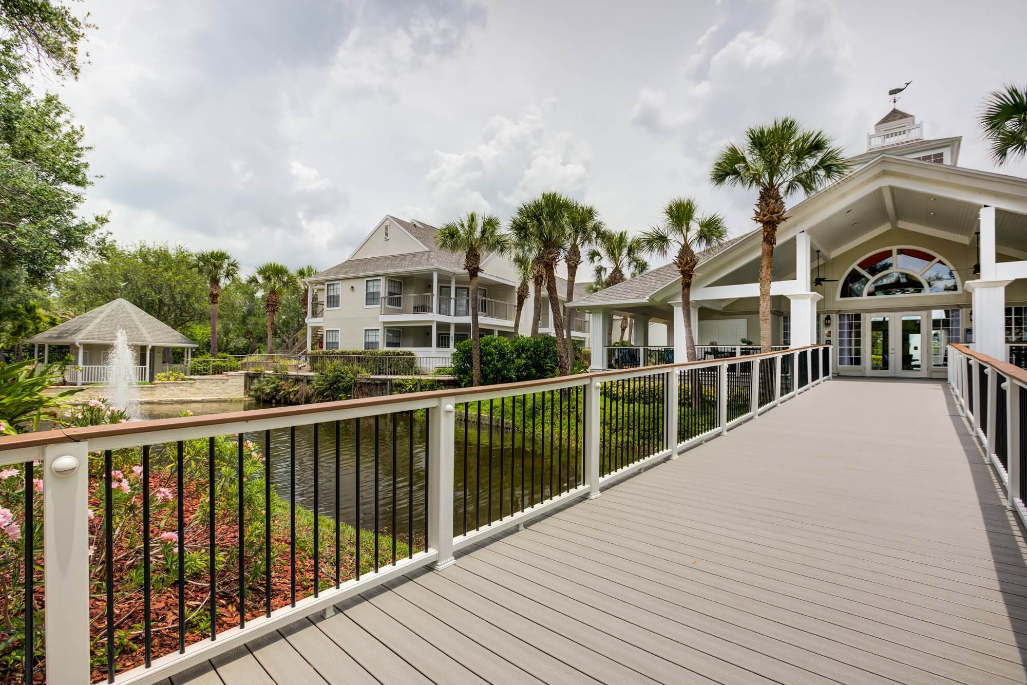 large wooden walkway to clubhouse with view of the fountain.
