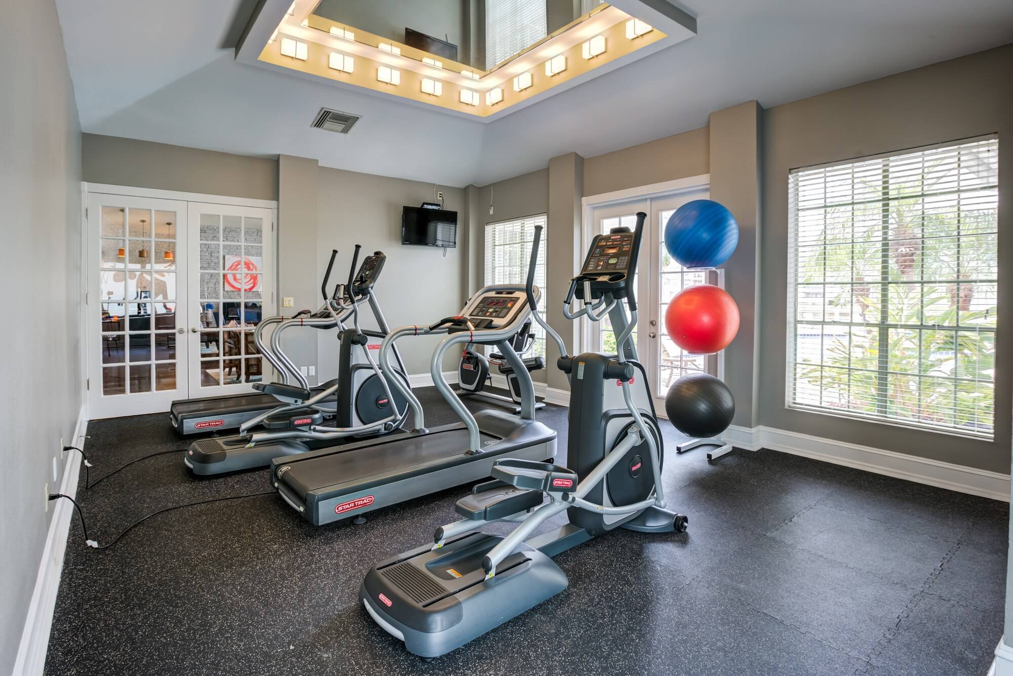 fitness center with pilate balls, treadmill, and elliptical.