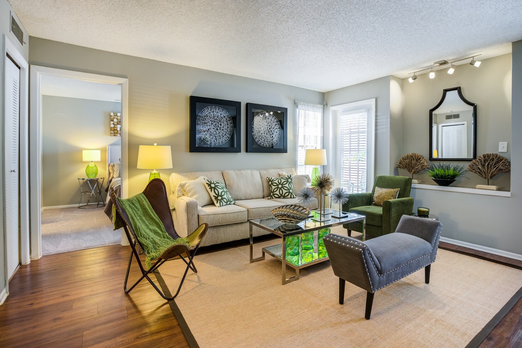 living area with wood floors, decor, and view of bedroom.