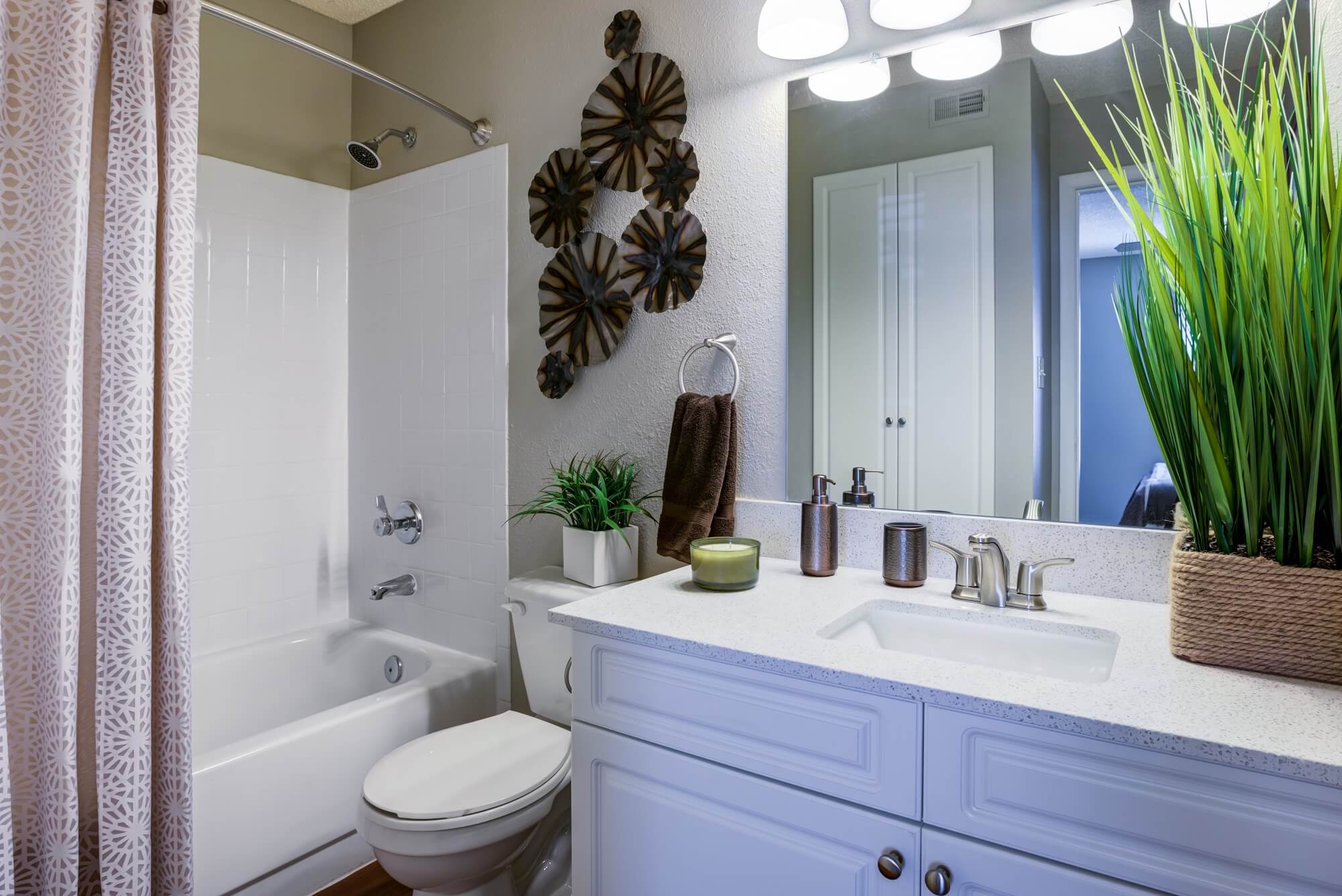 bathroom with single sink, tub, toilet, and decor.